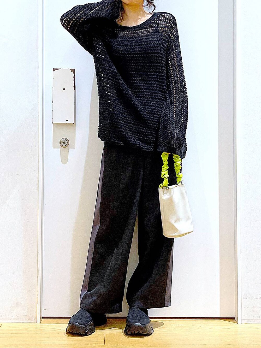 グリーン系のショルダーバッグ、ブラック系のその他パンツ、ブラック系のスニーカーを着用したレディースの春コーディネートの6枚目の写真