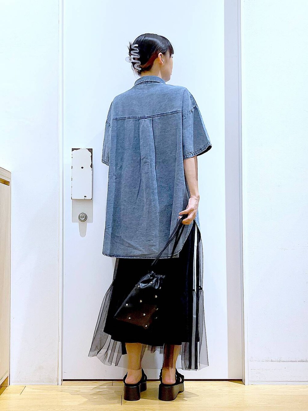 ブラック系のサンダル、ブラック系のショルダーバッグ、ブルー系のシャツ/ブラウスを着用したレディースの夏コーディネートの5枚目の写真