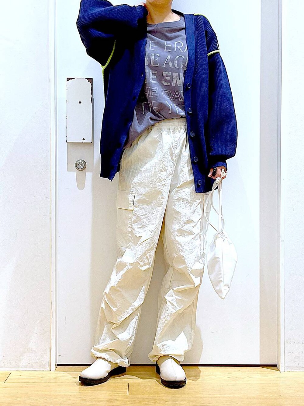 グレー系のTシャツ/カットソー、ベージュ系のブーツ、ホワイト系のショルダーバッグを着用したレディースの冬コーディネートの6枚目の写真