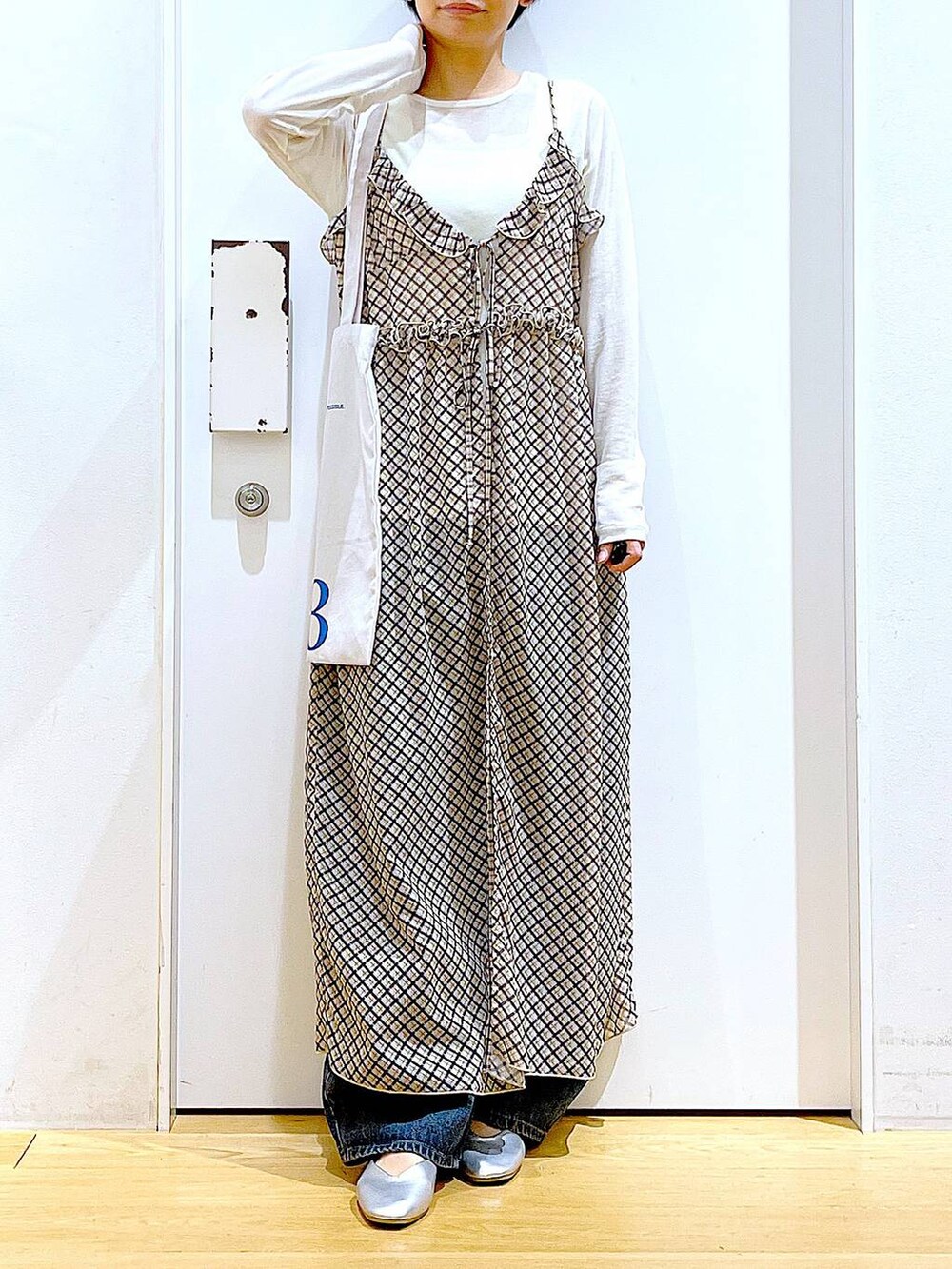 ブルー系のデニムパンツ、シルバー系のパンプス、ホワイト系のTシャツ/カットソーを着用したレディースの春コーディネートの6枚目の写真