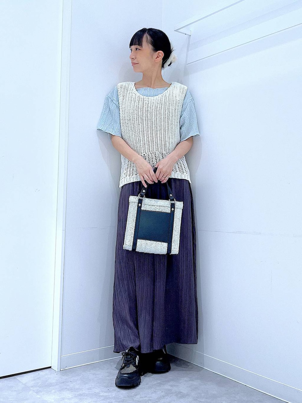 ホワイト系のショルダーバッグ、ブラック系のスニーカー、ブルー系のTシャツ/カットソーを着用したレディースの春コーディネートの2枚目の写真