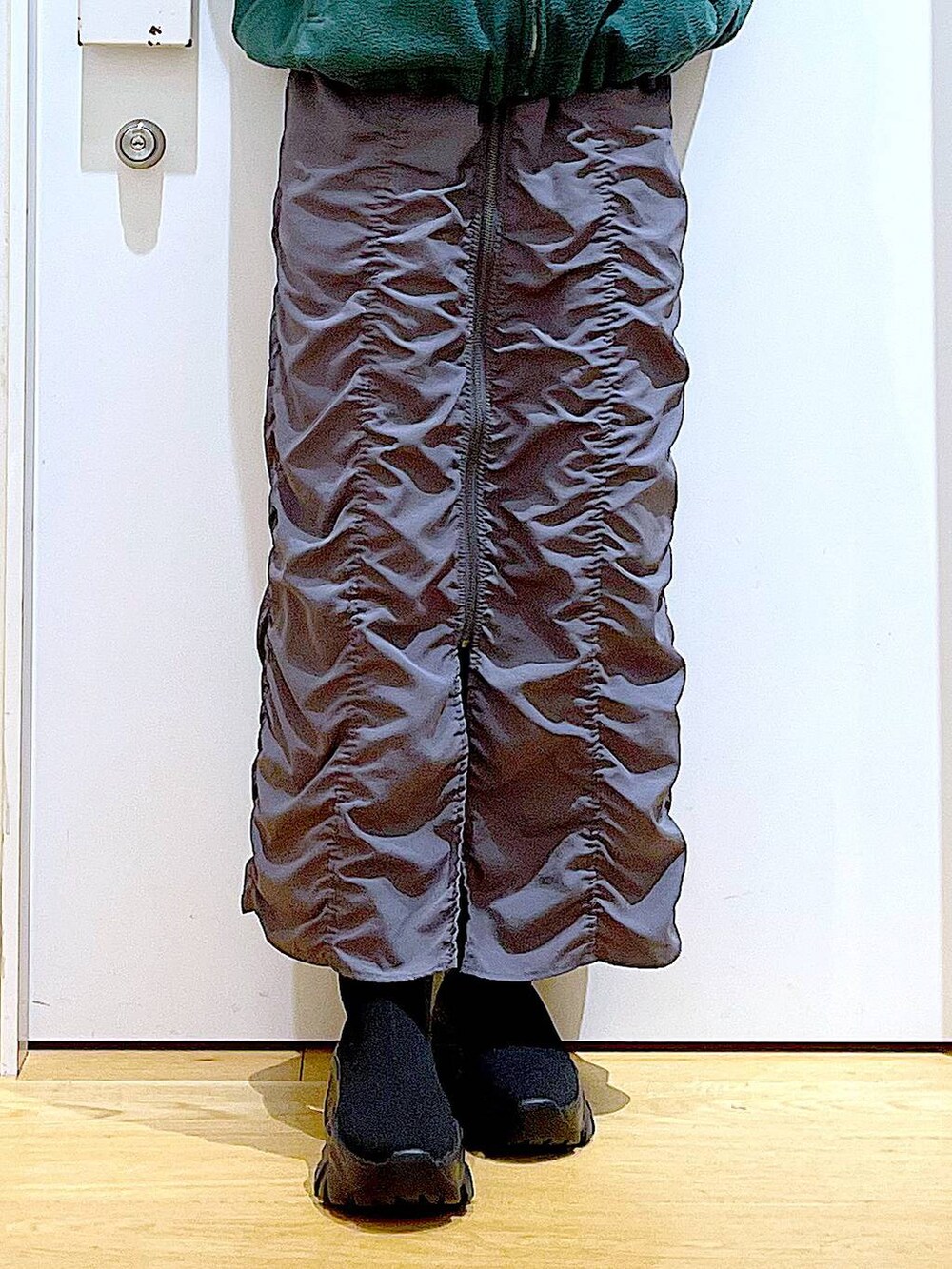 ブラック系のバックパック/リュック、グレー系のスカート、ブラック系のブーツを着用したレディースの冬コーディネートの8枚目の写真