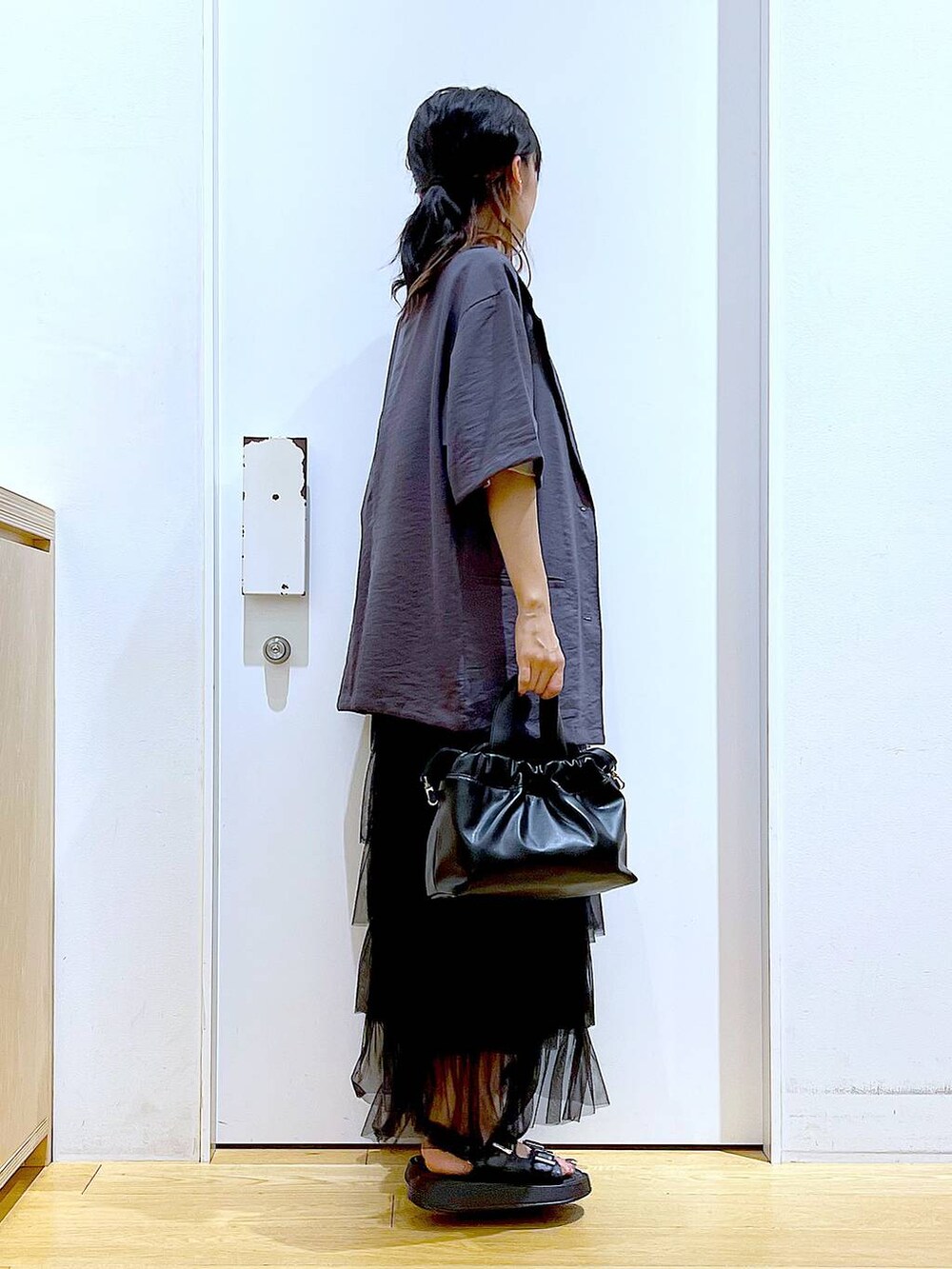 ブラック系のサンダル、ブラック系のショルダーバッグ、ブラック系のスカートを着用したレディースの夏コーディネートの4枚目の写真