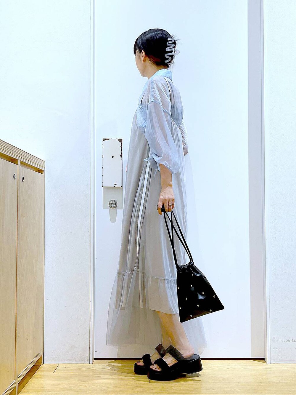 ブラック系のサンダル、ブラック系のショルダーバッグ、ブルー系のシャツ/ブラウスを着用したレディースの夏コーディネートの3枚目の写真