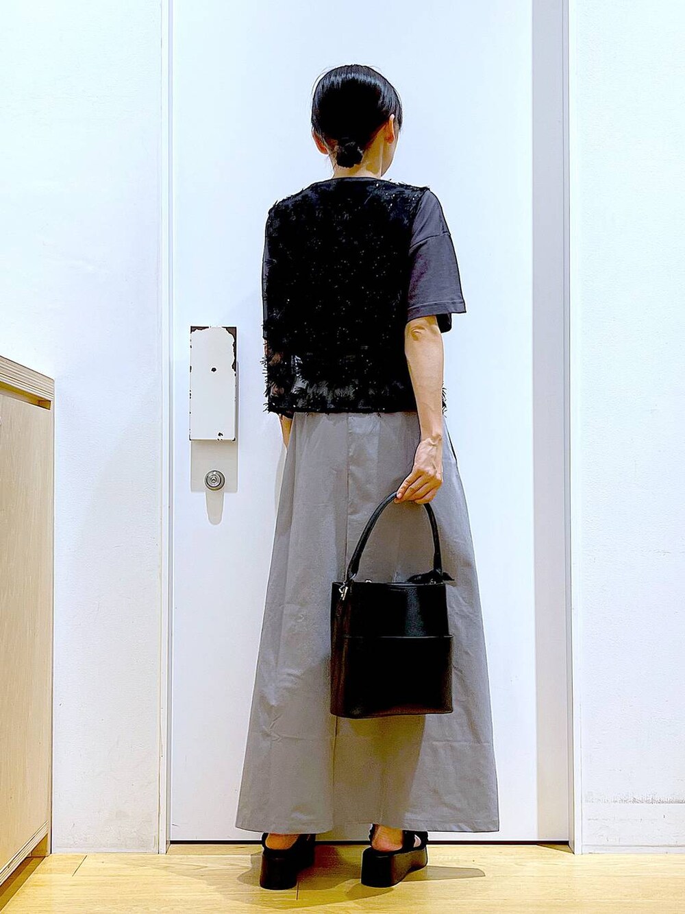 ブラック系のサンダル、ブラック系のショルダーバッグ、グレー系のスカートを着用したレディースの秋コーディネートの5枚目の写真