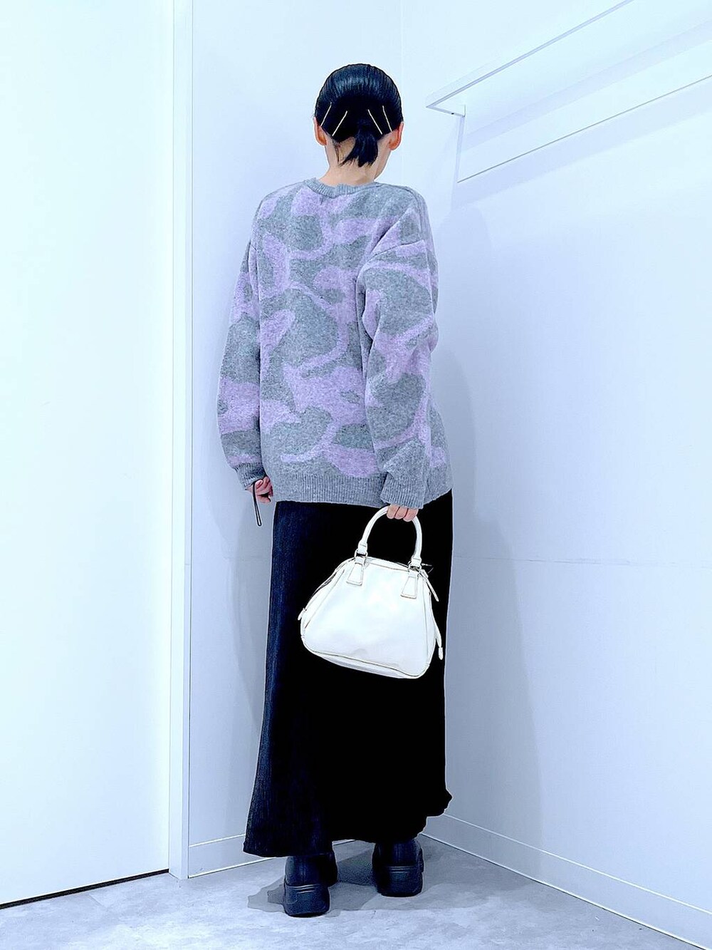 ブラック系のブーツ、グレー系のニット/セーター、ブラック系のスカートを着用したレディースの冬コーディネートの5枚目の写真