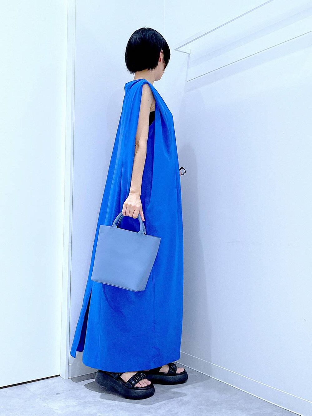 ブラック系のサンダル、ブルー系のワンピース、ブルー系のショルダーバッグを着用したレディースの夏コーディネートの4枚目の写真