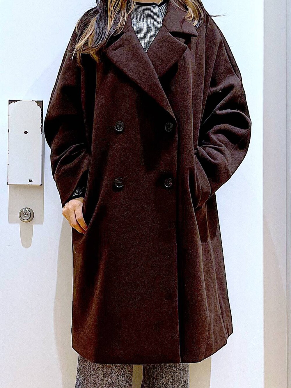 ブラウン系のステンカラーコート、ブラック系のショルダーバッグ、その他のニット/セーターを着用したレディースの冬コーディネートの7枚目の写真