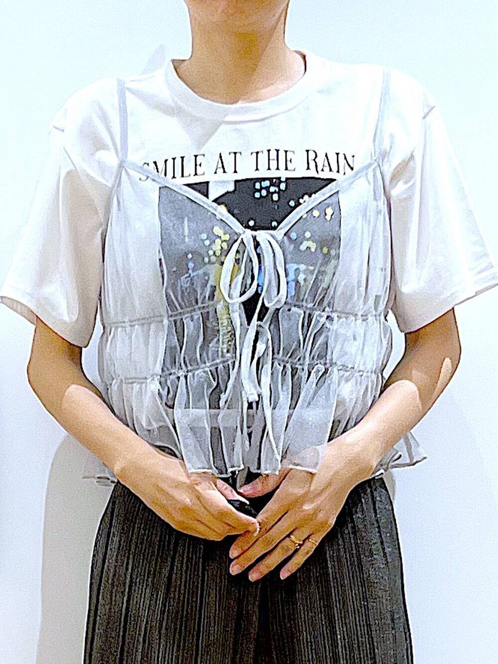 グリーン系のトートバッグ、シルバー系のキャミソール、ホワイト系のTシャツ/カットソーを着用したレディースの夏コーディネートの7枚目の写真