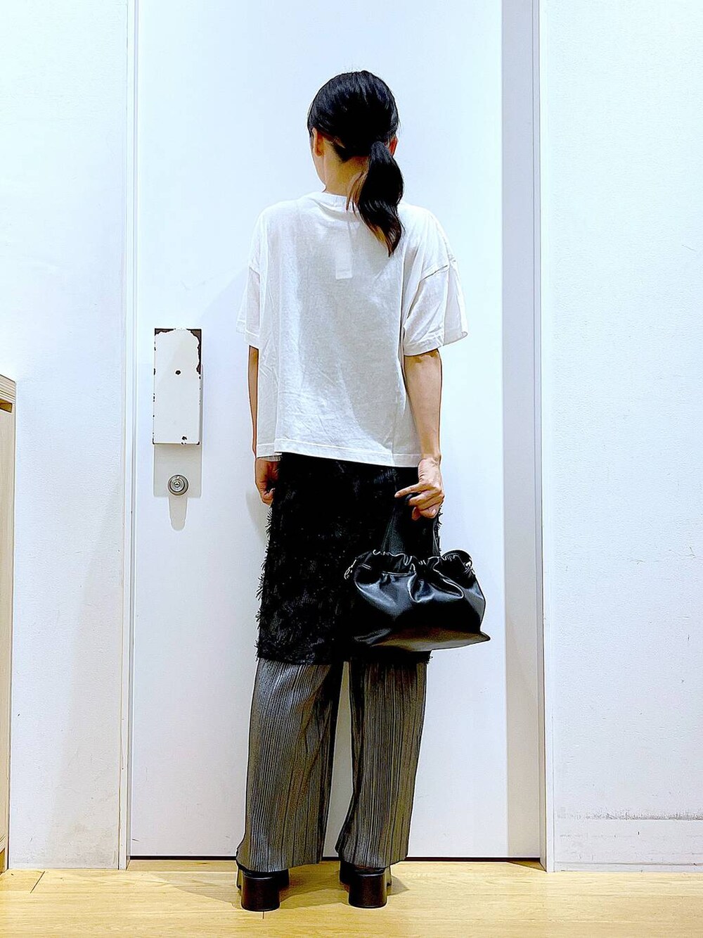 ブラック系のサンダル、ブラック系のショルダーバッグ、ブラック系のスカートを着用したレディースの秋コーディネートの5枚目の写真