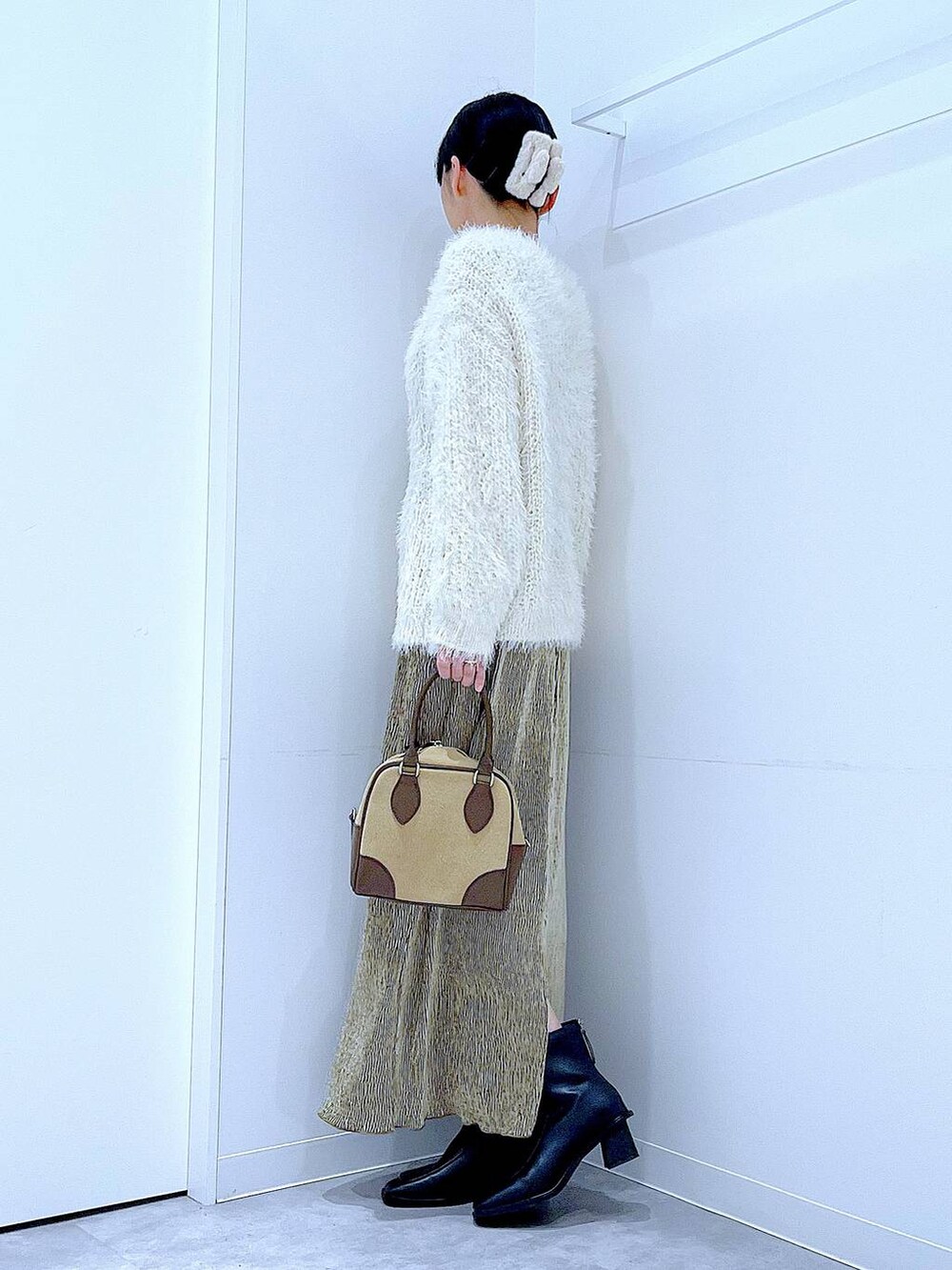 ベージュ系のハンドバッグ、ブラック系のブーツ、ベージュ系のニット/セーターを着用したレディースの冬コーディネートの3枚目の写真