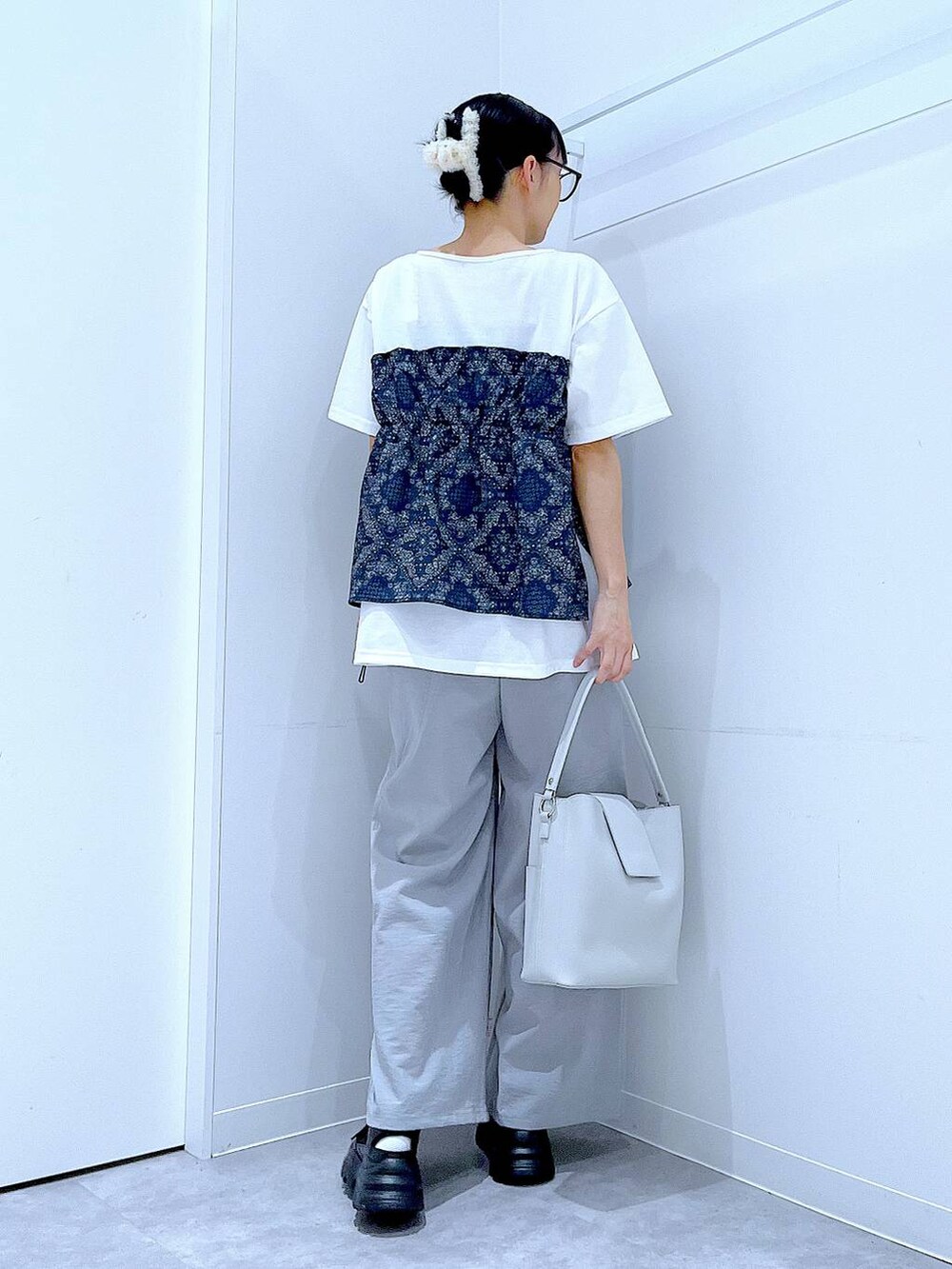 ブラック系のスニーカー、ホワイト系のTシャツ/カットソー、グレー系のその他パンツを着用したレディースの春コーディネートの5枚目の写真