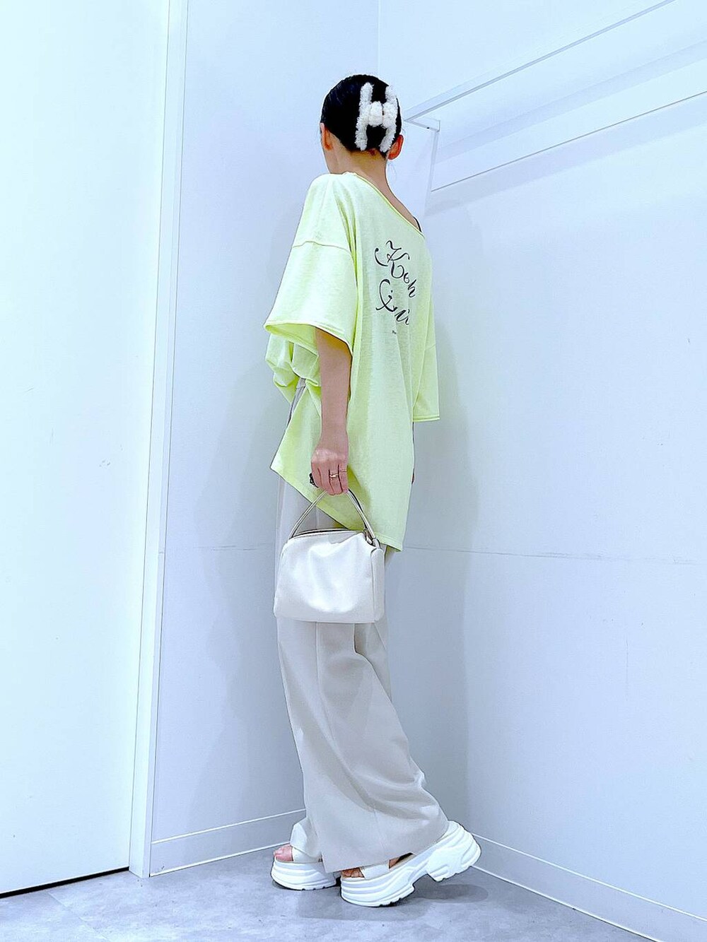 ホワイト系のショルダーバッグ、イエロー系のTシャツ/カットソー、ホワイト系のサンダルを着用したレディースの夏コーディネートの3枚目の写真