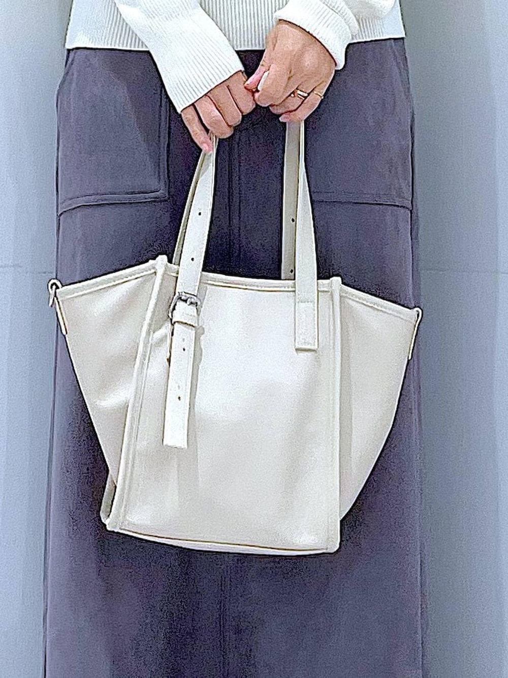 ブラック系のブーツ、グレー系のスカート、ベージュ系のニット/セーターを着用したレディースの冬コーディネートの9枚目の写真