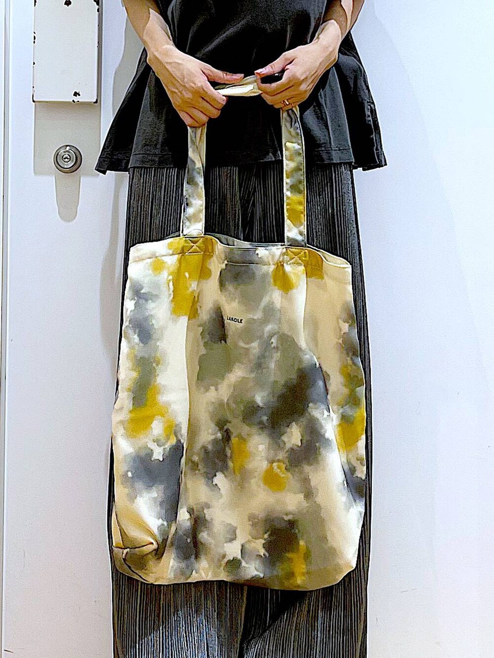 ホワイト系のサンダル、イエロー系のトートバッグ、グレー系のその他パンツを着用したレディースの秋コーディネートの9枚目の写真