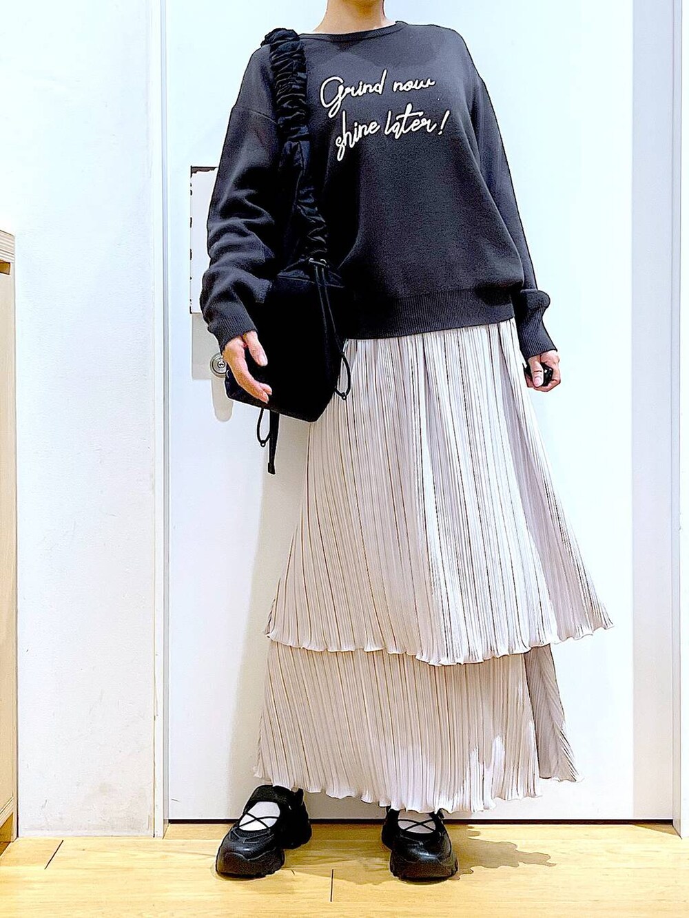 ブラック系のショルダーバッグ、ブラック系のスニーカー、グレー系のニット/セーターを着用したレディースの夏コーディネートの6枚目の写真