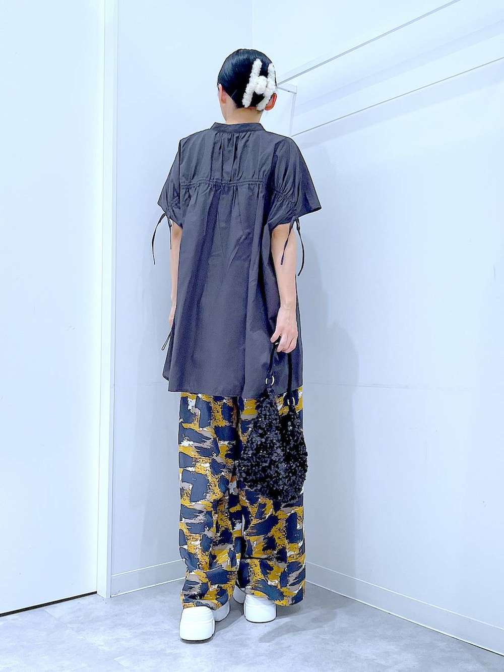 グレー系のその他パンツ、ブラック系のショルダーバッグ、ホワイト系のサンダルを着用したレディースの夏コーディネートの5枚目の写真