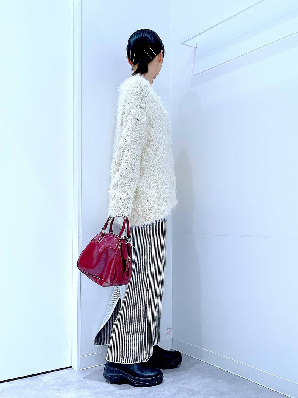 ブラック系のブーツ、ベージュ系のスカート、ベージュ系のカーディガン/ボレロを着用したレディースの秋コーディネートの4枚目の写真