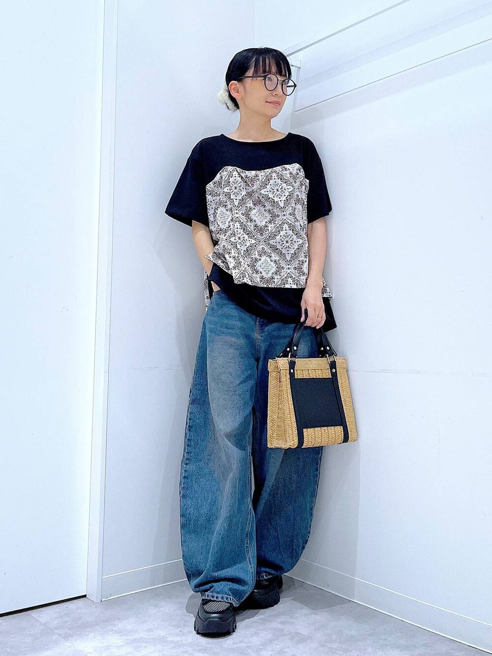 ブルー系のデニムパンツ、ブラック系のスニーカー、ブラック系のTシャツ/カットソーを着用したレディースの春コーディネートの2枚目の写真