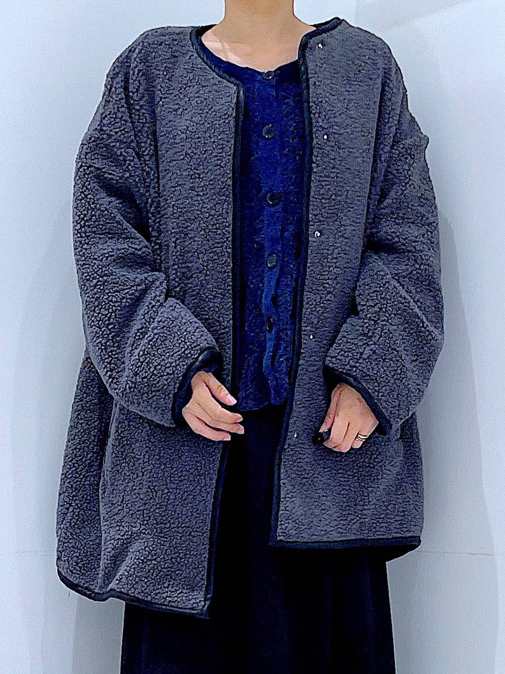 ブラック系のスカート、グレー系のブルゾン、ブラック系のブーツを着用したレディースの秋コーディネートの7枚目の写真