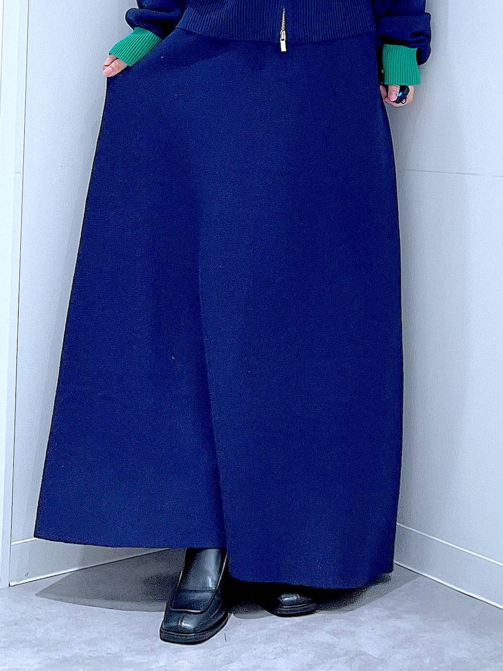 ブラック系のショルダーバッグ、ブラック系のブーツ、ブルー系のスカートを着用したレディースの冬コーディネートの8枚目の写真