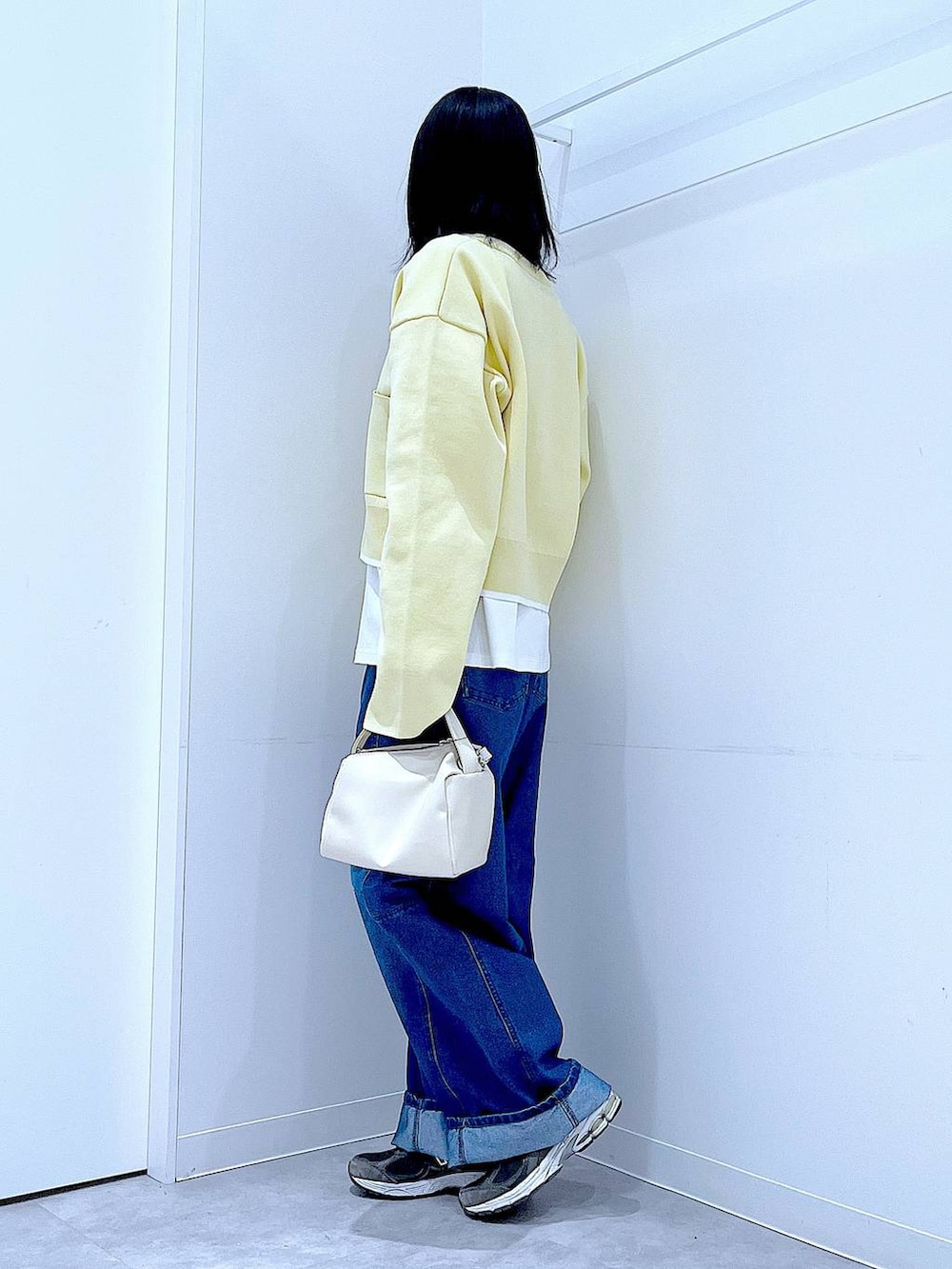 ホワイト系のショルダーバッグ、ホワイト系のTシャツ/カットソー、ブルー系のデニムパンツを着用したレディースの春コーディネートの3枚目の写真
