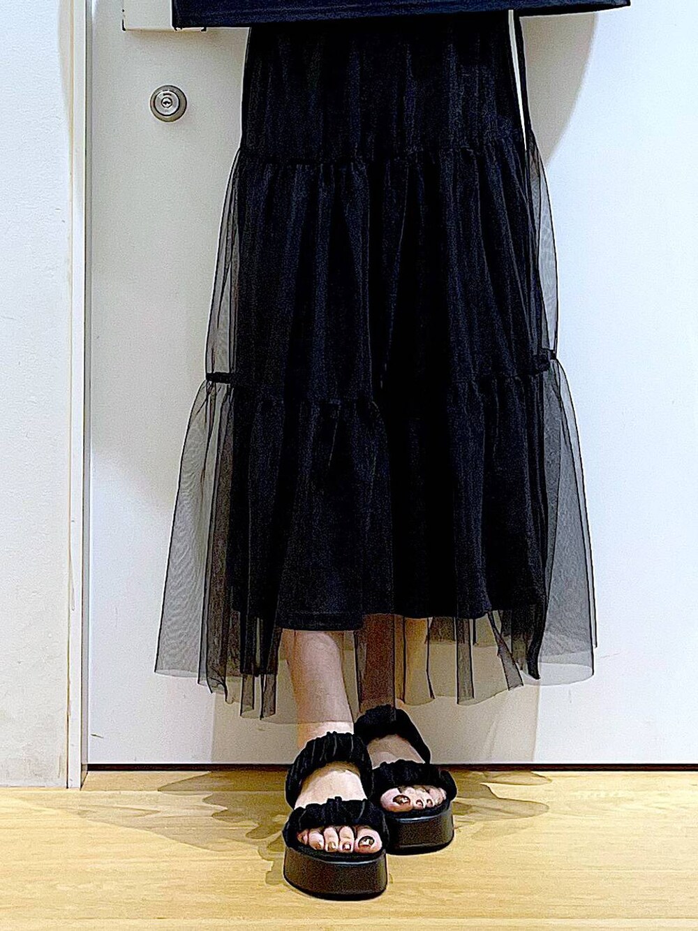 ホワイト系のバックパック/リュック、ブラック系のサンダル、ブラック系のスカートを着用したレディースの夏コーディネートの8枚目の写真