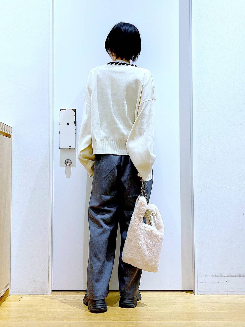 ホワイト系のショルダーバッグ、ブラック系のブーツ、グレー系のその他パンツを着用したレディースの冬コーディネートの5枚目の写真