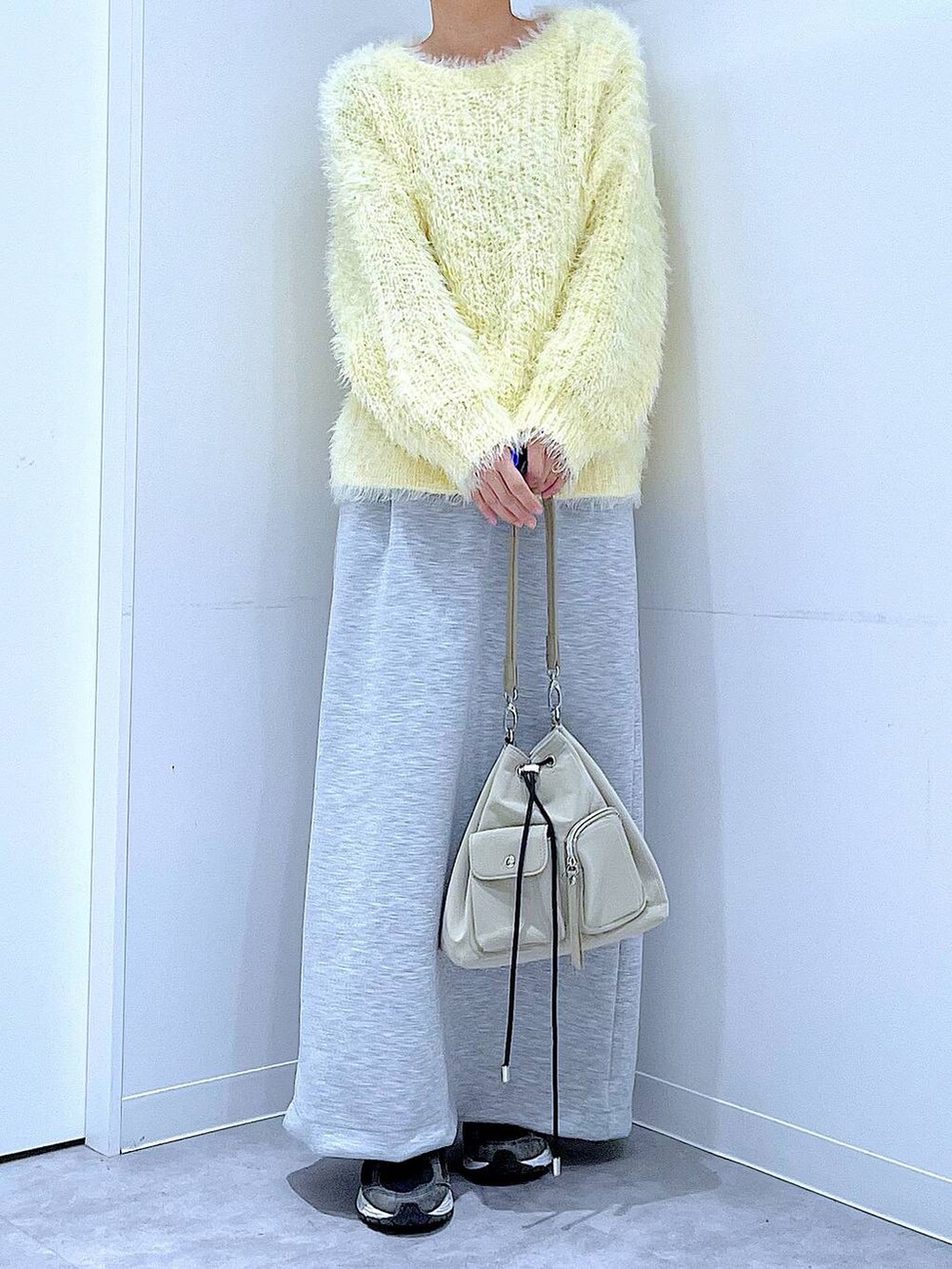 イエロー系のニット/セーター、グレー系のスカート、パープル系のバレッタ/ヘアクリップを着用したレディースの冬コーディネートの6枚目の写真