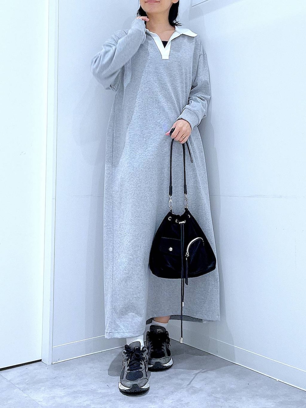 ブラック系のショルダーバッグ、グレー系のワンピース、ブラック系のキャップを着用したレディースの春コーディネートの6枚目の写真