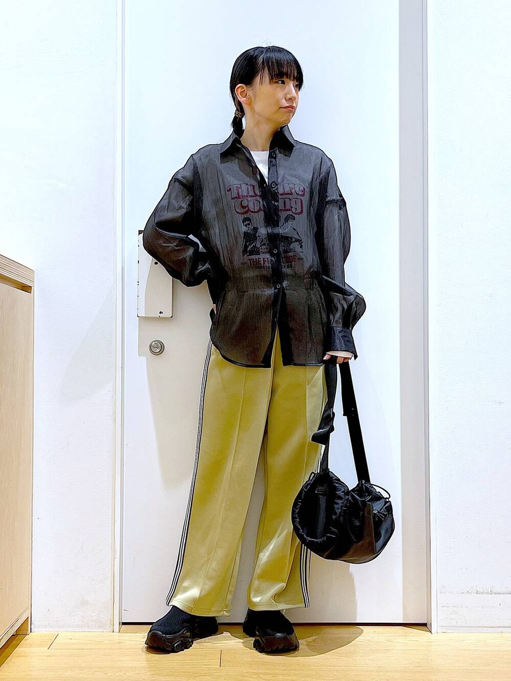 グリーン系のその他パンツ、ブラック系のスニーカー、ブラック系のショルダーバッグを着用したレディースの春コーディネートの2枚目の写真