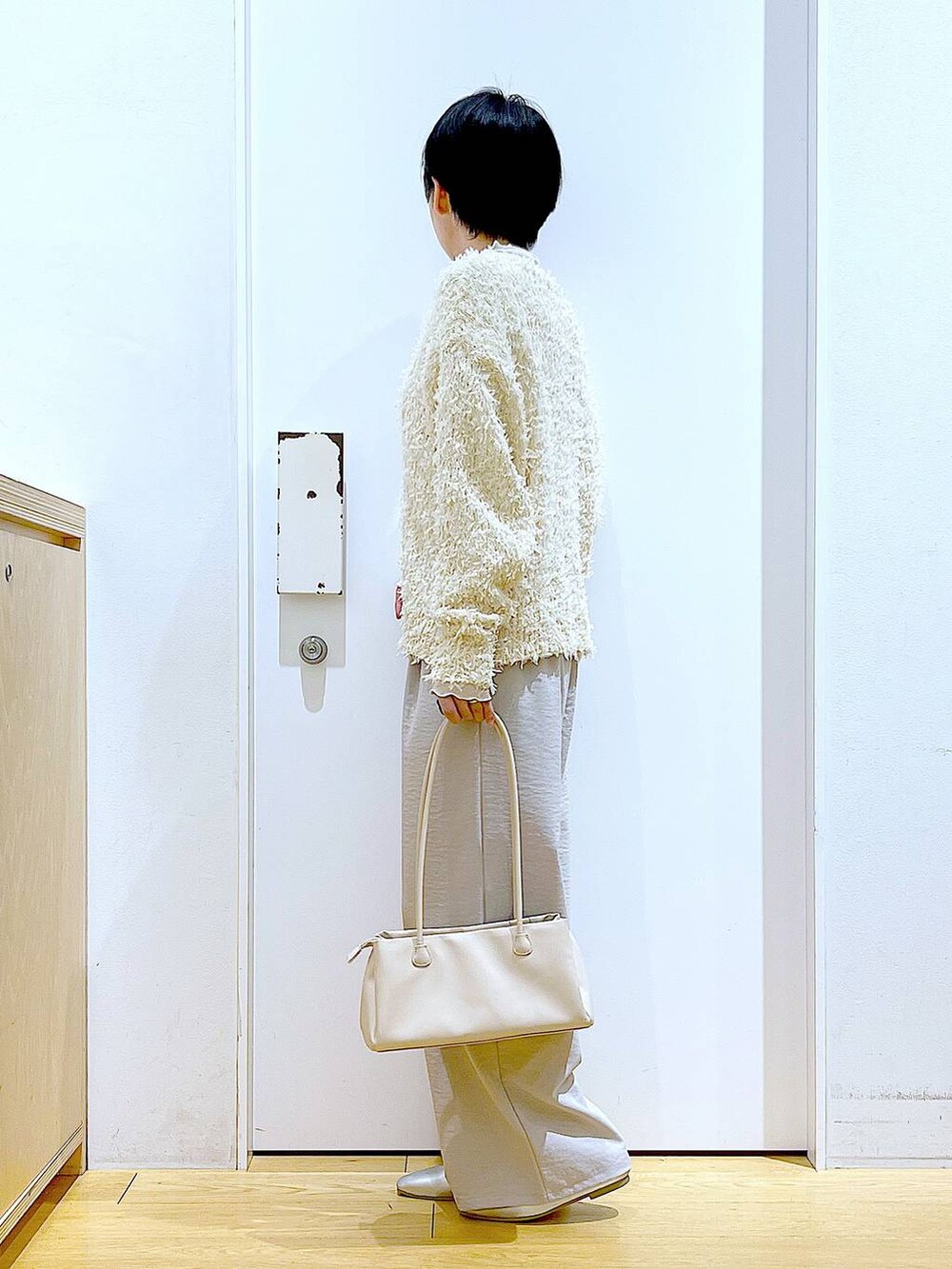 ホワイト系のトートバッグ、ベージュ系のTシャツ/カットソー、シルバー系のパンプスを着用したレディースの冬コーディネートの3枚目の写真