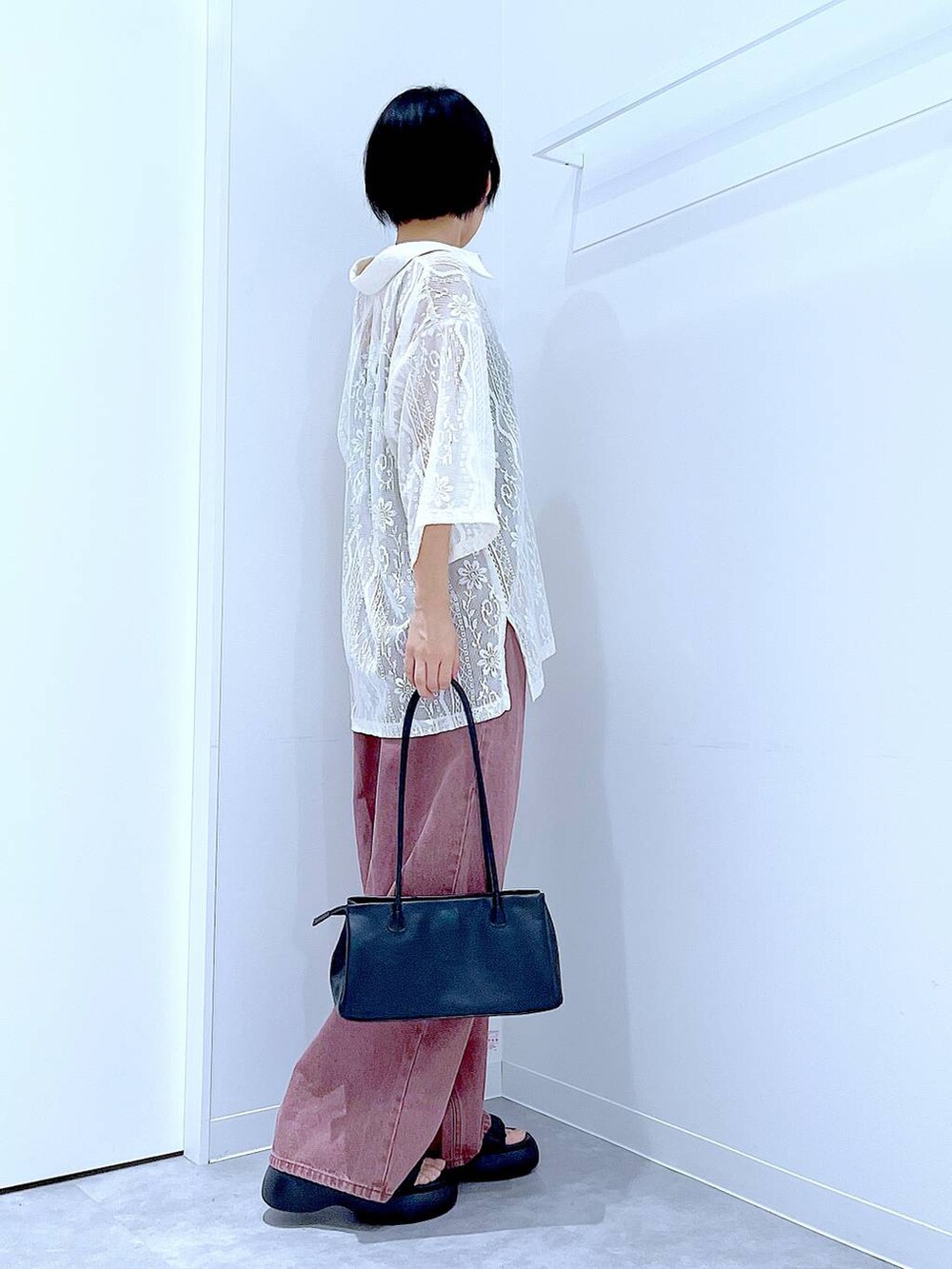 ブラック系のトートバッグ、ブラック系のサンダル、ホワイト系のシャツ/ブラウスを着用したレディースの夏コーディネートの4枚目の写真