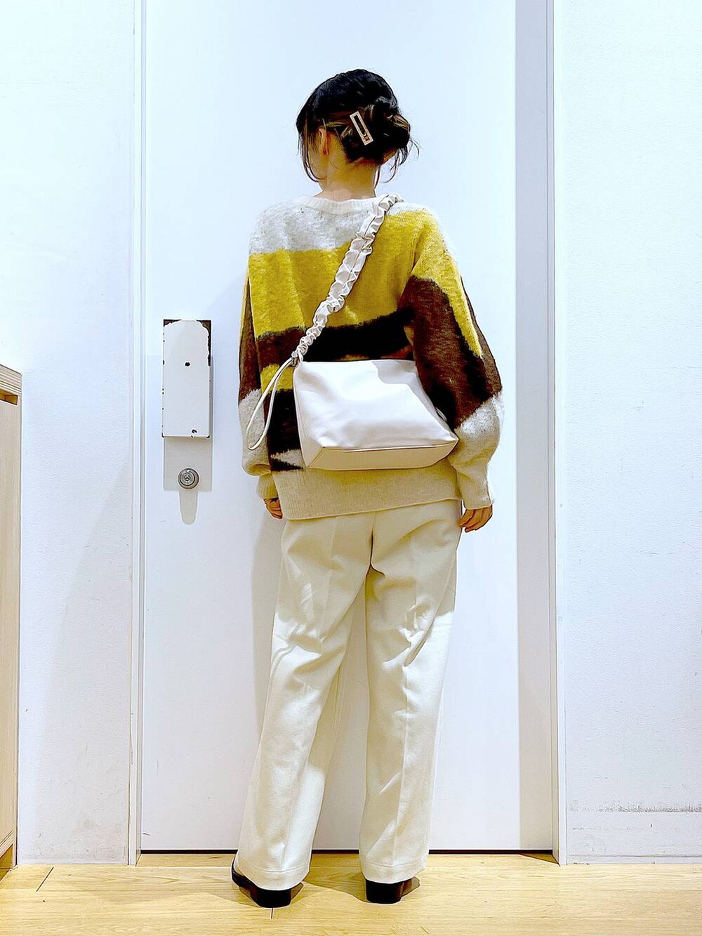 ホワイト系のショルダーバッグ、ベージュ系のブーツ、ベージュ系のその他パンツを着用したレディースの冬コーディネートの5枚目の写真