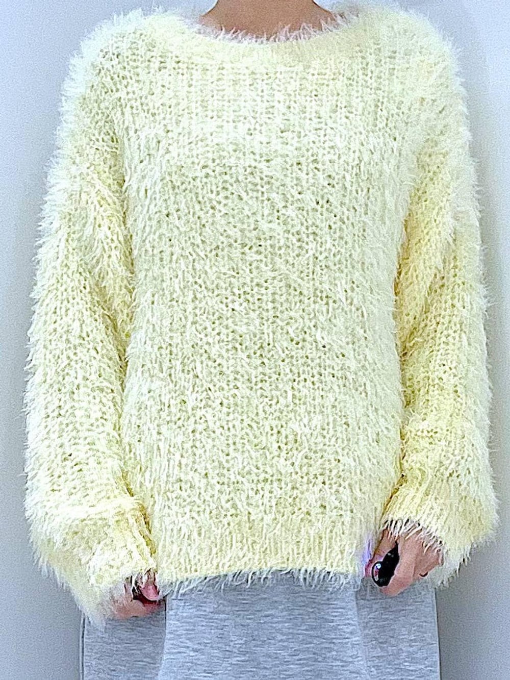 イエロー系のニット/セーター、グレー系のスカート、パープル系のバレッタ/ヘアクリップを着用したレディースの冬コーディネートの7枚目の写真