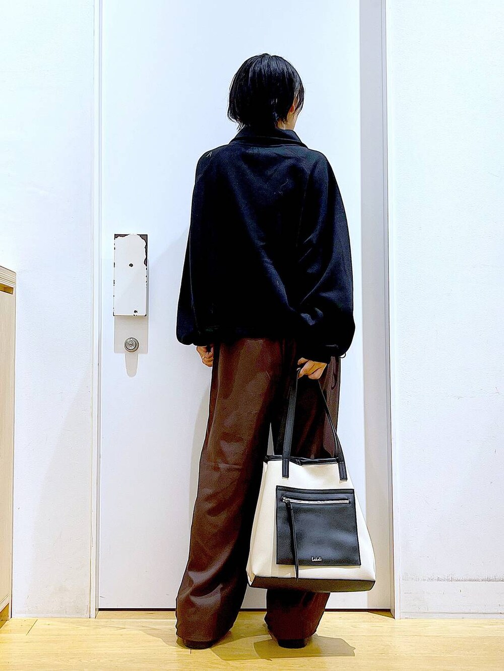 ブラック系のスリッポン、ブラウン系のその他パンツ、ホワイト系のトートバッグを着用したレディースの秋コーディネートの5枚目の写真