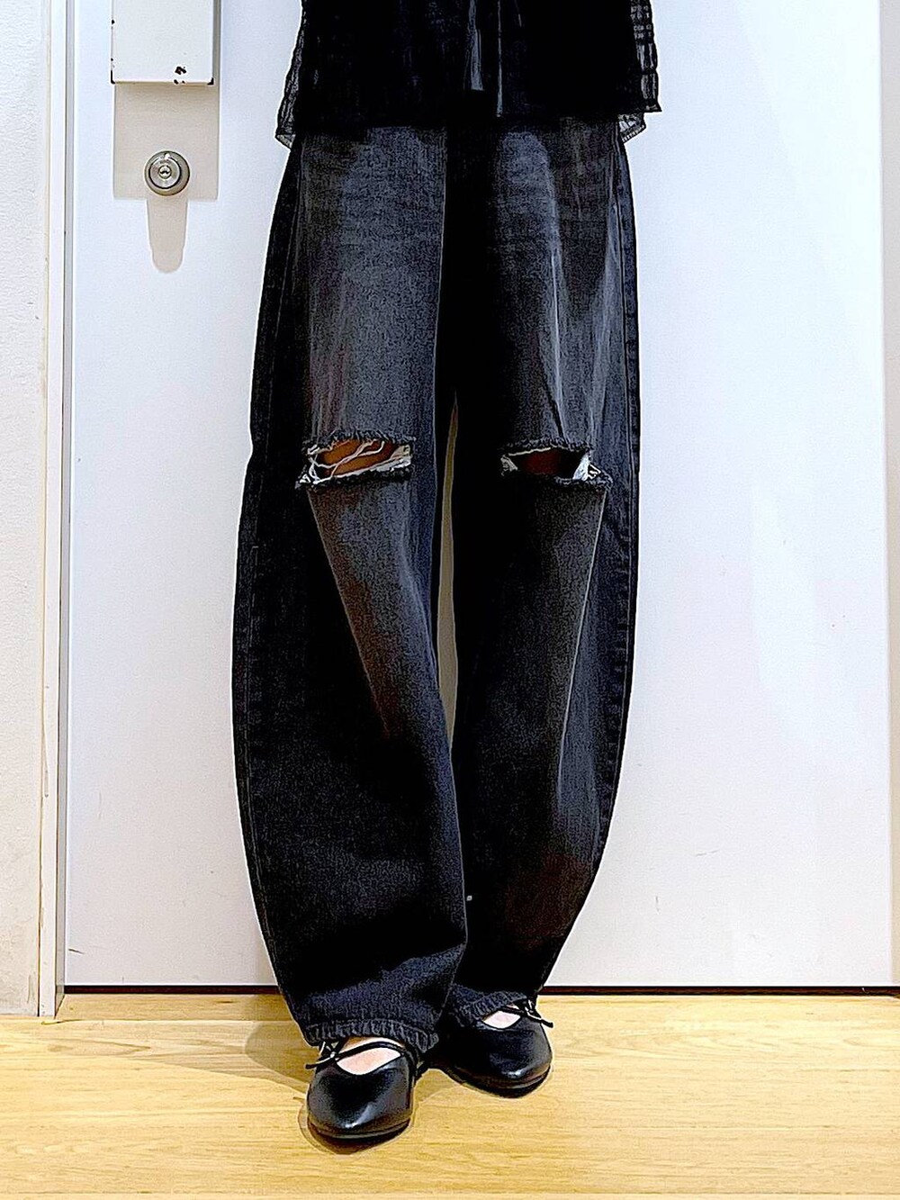 シルバー系のトートバッグ、ブラック系のデニムパンツ、ブラック系のカーディガン/ボレロを着用したレディースの秋コーディネートの8枚目の写真