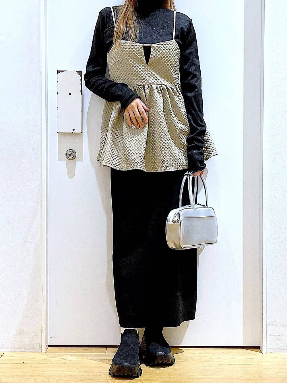 シルバー系のショルダーバッグ、ブラック系のTシャツ/カットソー、ブラック系のスニーカーを着用したレディースの春コーディネートの6枚目の写真