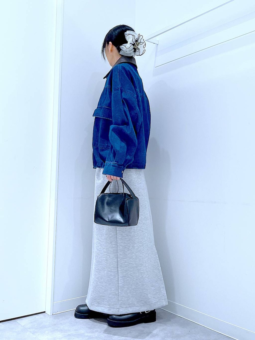 ブラック系のショルダーバッグ、グレー系のスカート、ブラック系のサンダルを着用したレディースの春コーディネートの3枚目の写真