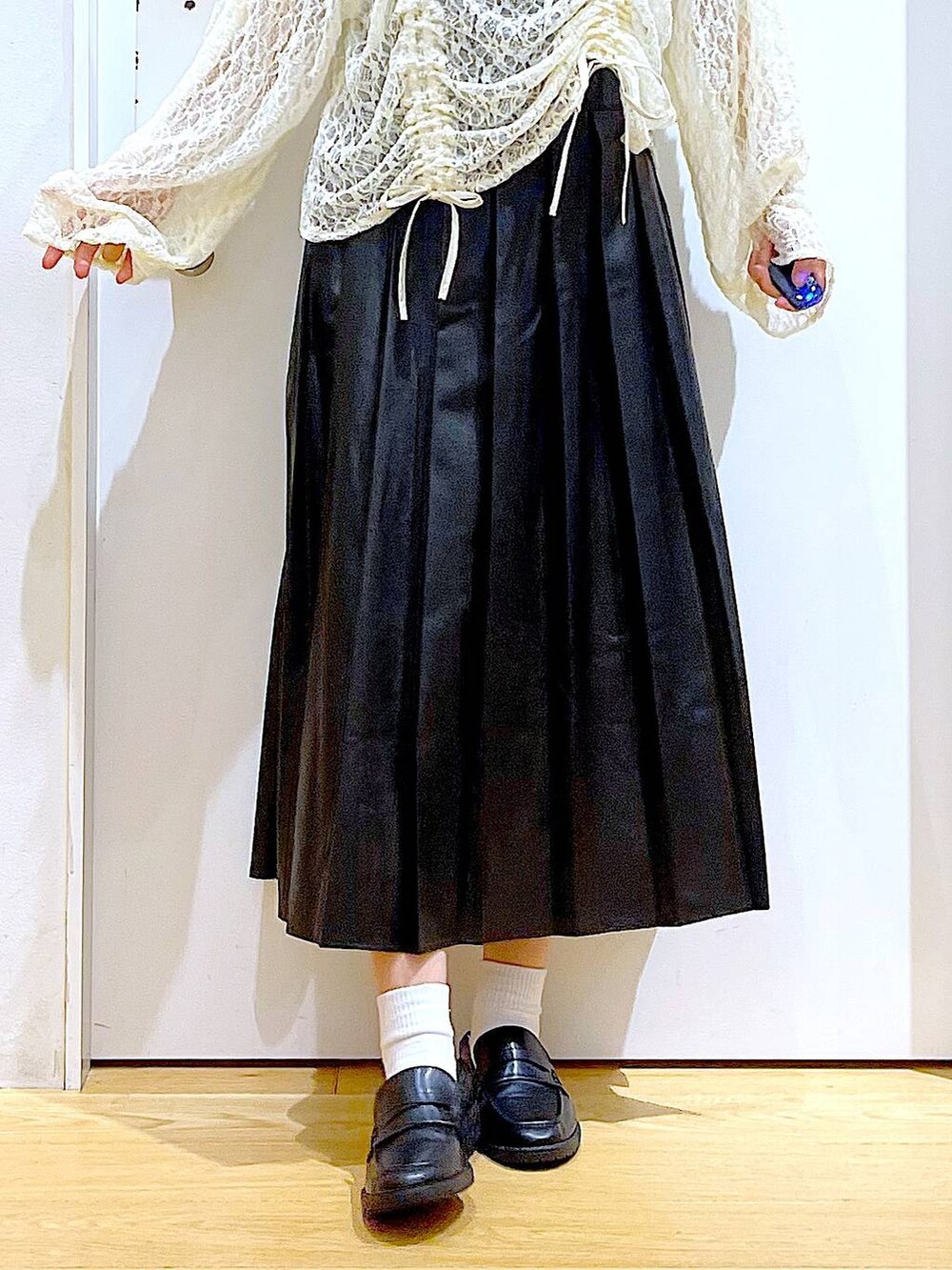 ブラック系のショルダーバッグ、ブラック系のローファー、ベージュ系のTシャツ/カットソーを着用したレディースの秋コーディネートの8枚目の写真