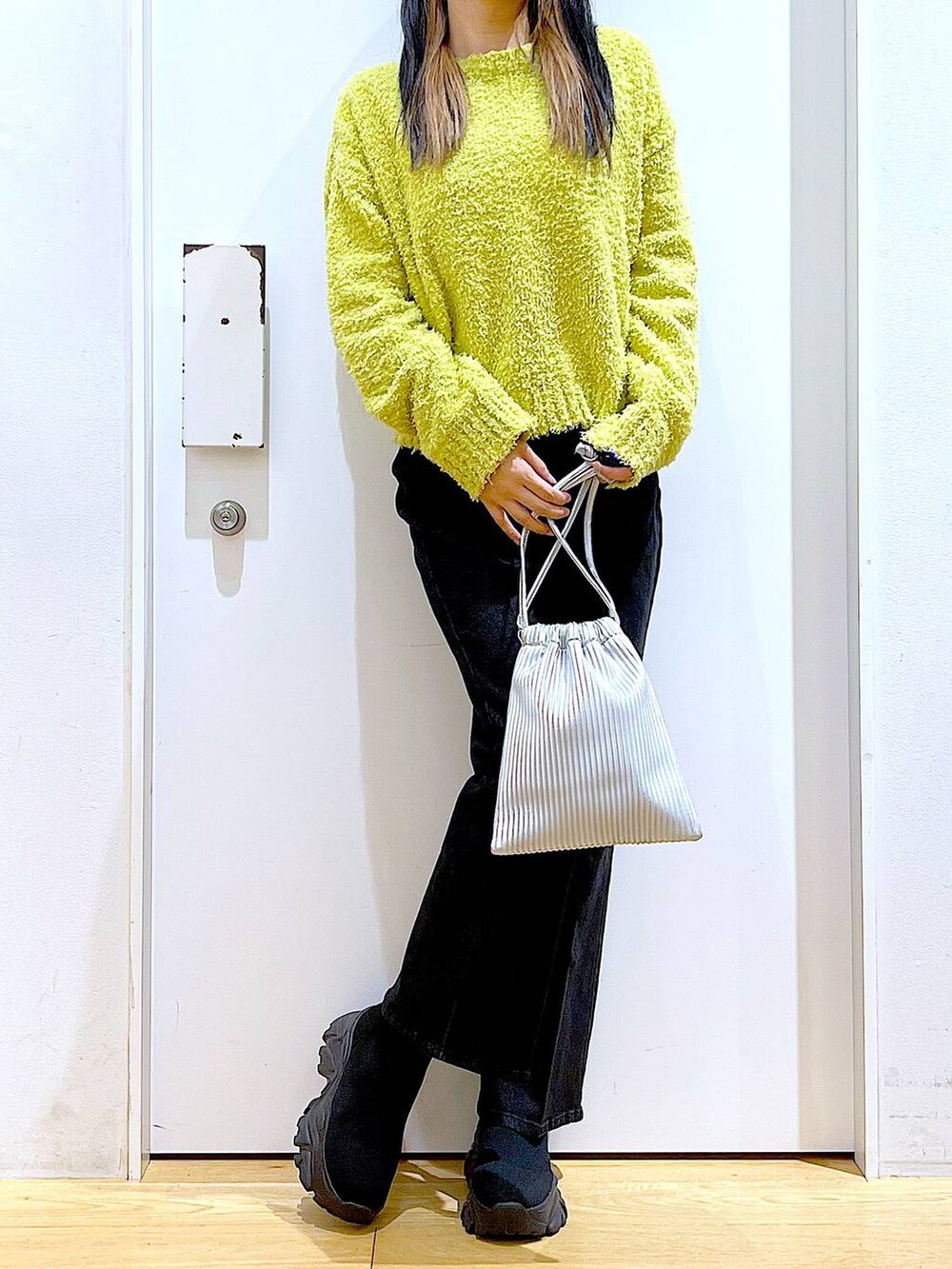 グリーン系のニット/セーター、グレー系のデニムパンツ、シルバー系のショルダーバッグを着用したレディースの冬コーディネートの6枚目の写真