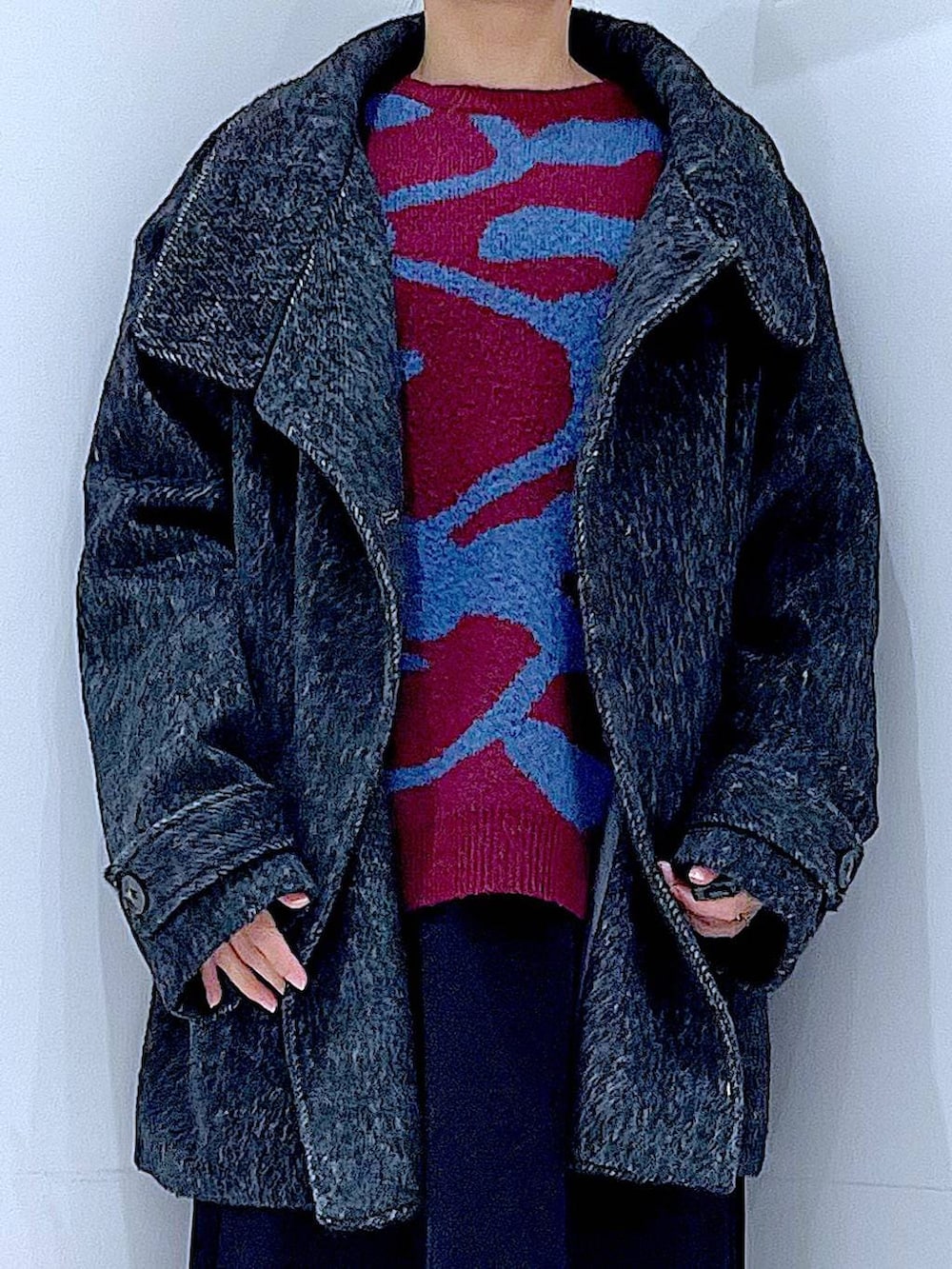 ブラック系のスカート、ブラック系のステンカラーコート、ブラック系のブーツを着用したレディースの冬コーディネートの7枚目の写真