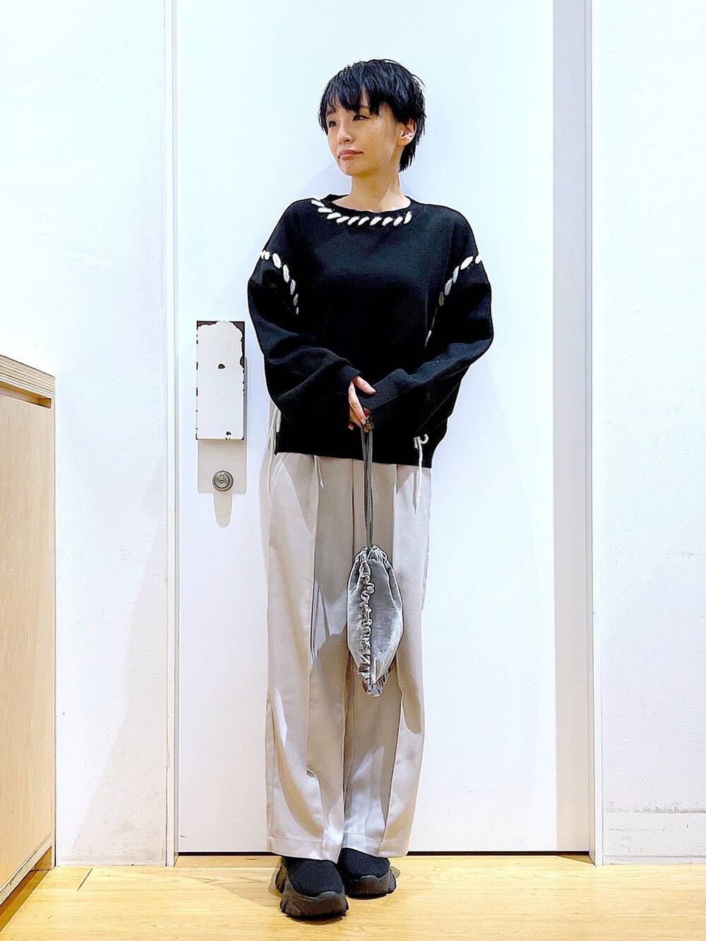 ブラック系のブーツ、グレー系のショルダーバッグ、ブラック系のニット/セーターを着用したレディースの冬コーディネートの2枚目の写真