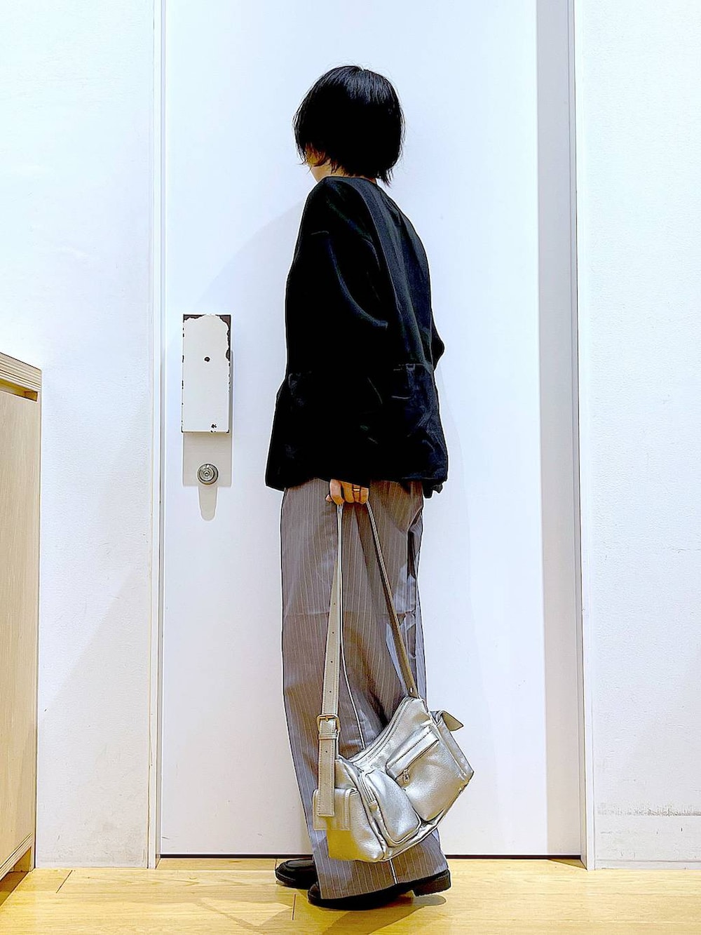 グレー系のスラックス、ブラック系のローファー、その他のショルダーバッグを着用したレディースの秋コーディネートの3枚目の写真