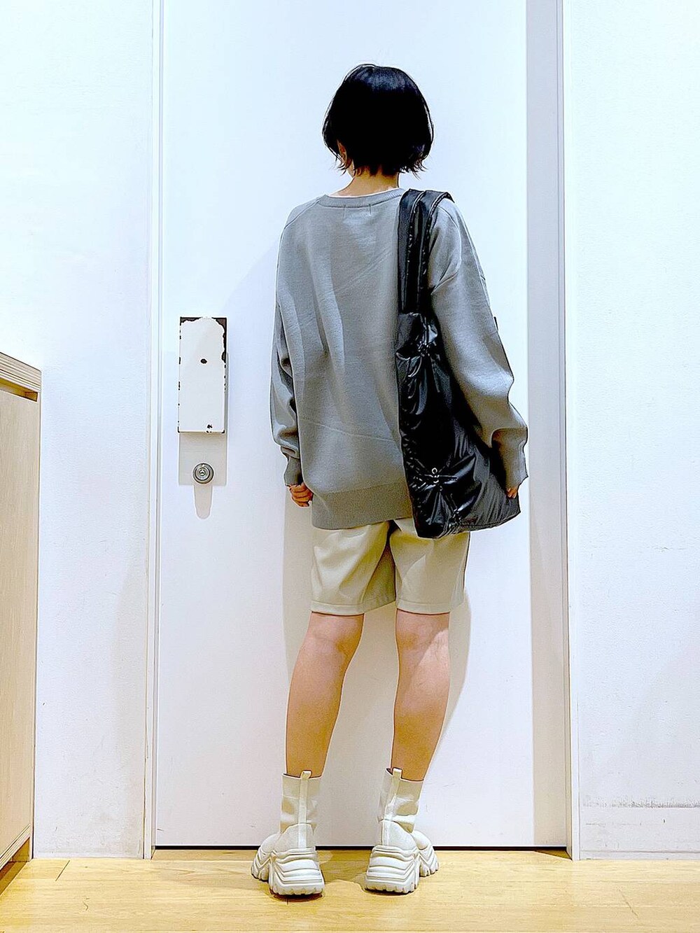 グレー系のニット/セーター、ブラック系のトートバッグ、ベージュ系のブーツを着用したレディースの冬コーディネートの5枚目の写真