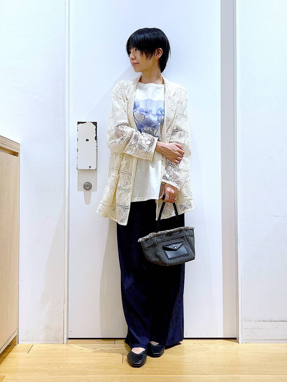 ブラック系のパンプス、ブラック系のショルダーバッグ、ホワイト系のテーラードジャケットを着用したレディースの春コーディネートの2枚目の写真