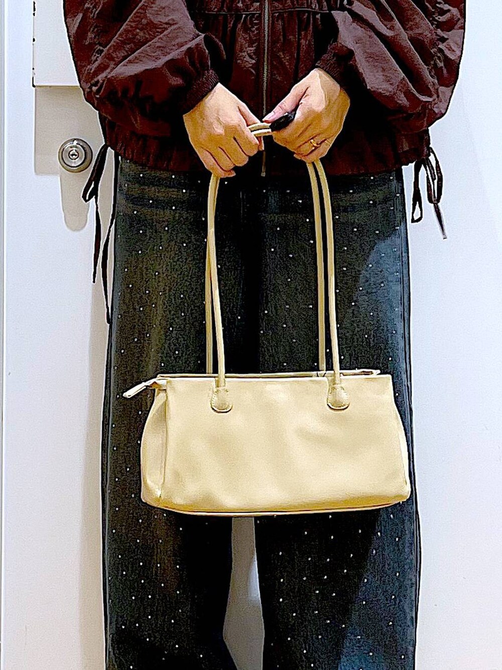 ブラック系のブーツ、ベージュ系のトートバッグ、ブラウン系のブルゾンを着用したレディースの冬コーディネートの9枚目の写真