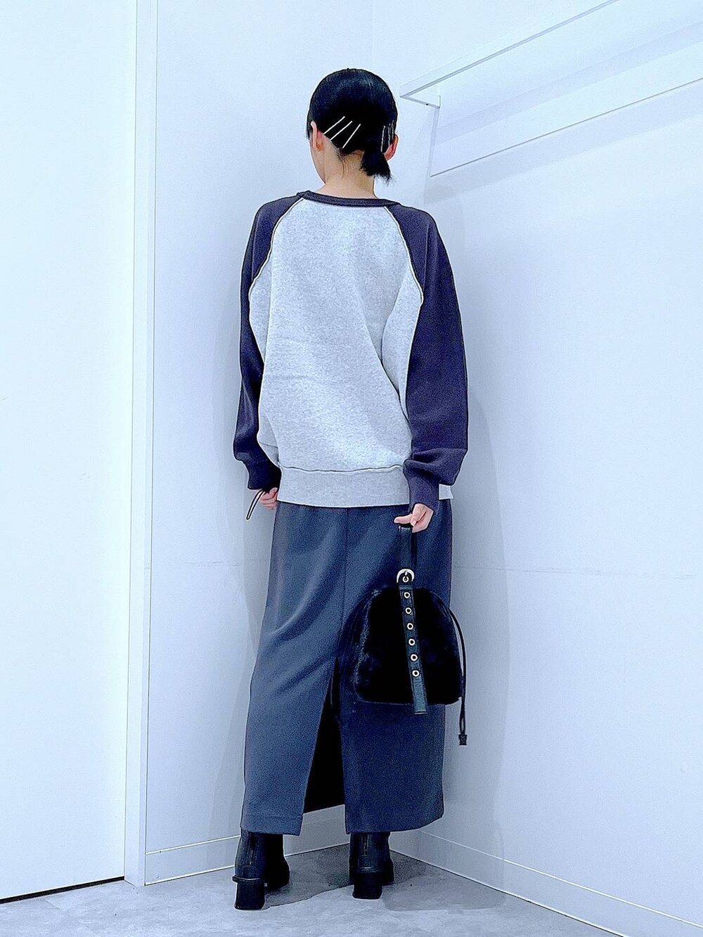 グレー系のスカート、グレー系のニット/セーター、ブラック系のブーツを着用したレディースの秋コーディネートの5枚目の写真