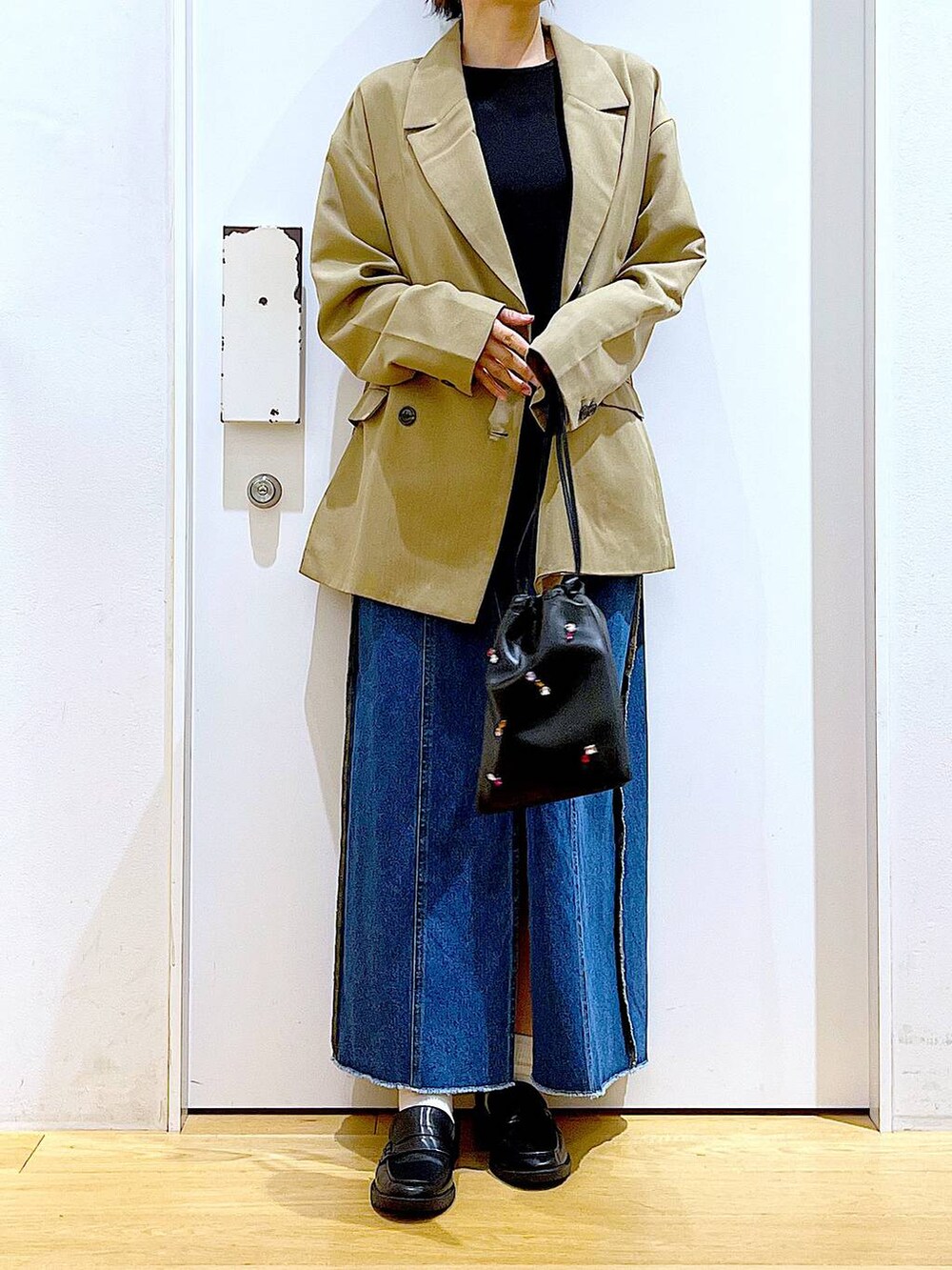 ブラック系のショルダーバッグ、ブラック系のローファー、ブラック系のTシャツ/カットソーを着用したレディースの秋コーディネートの6枚目の写真