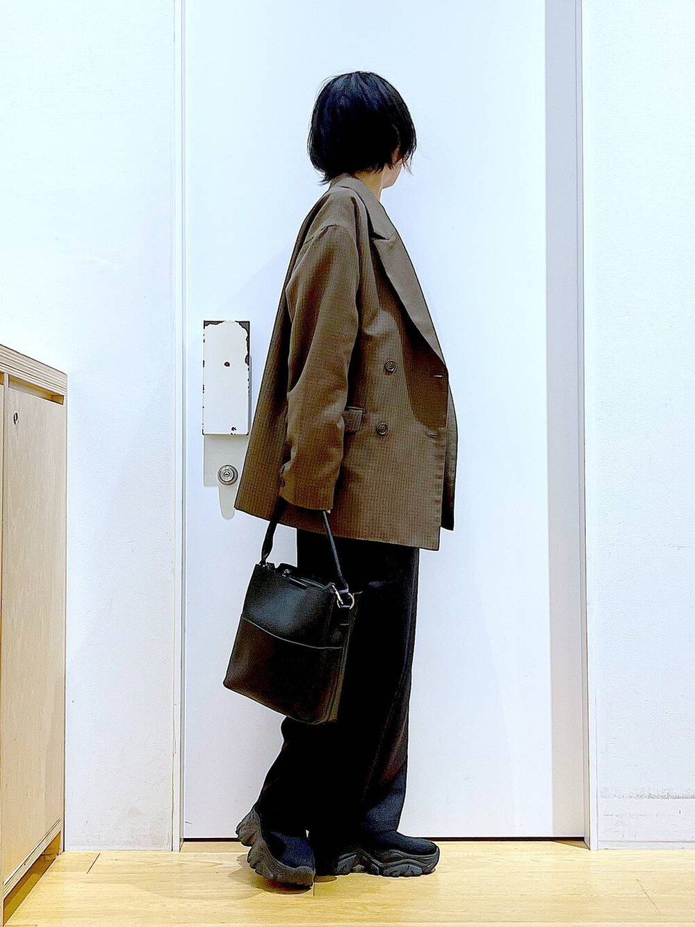 ブラック系のブーツ、ブラック系のショルダーバッグ、ブラウン系のテーラードジャケットを着用したレディースの秋コーディネートの4枚目の写真